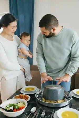 Parents at the dinner table engaging their baby with smiles and chatter—Baby Talking during a family mealtime.